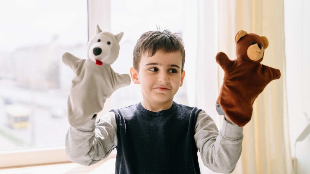 A child using animal puppets in a bright room, showing how imaginative play can support Autism and self-expression