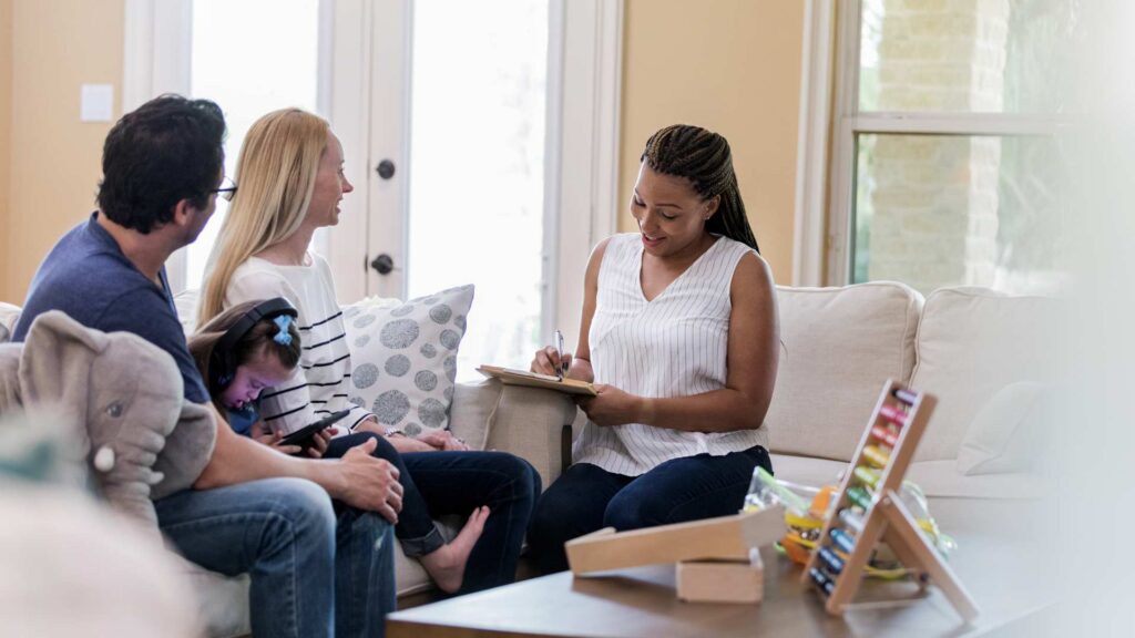 A relaxed family session with an ABA professional writing notes, showing care, understanding, and clear communication