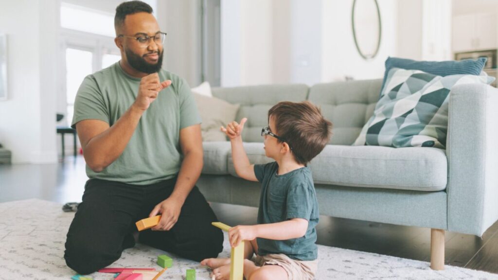 ABA therapist using ABA strategies at home to encourage communication and social interaction during a play-based learning activity.