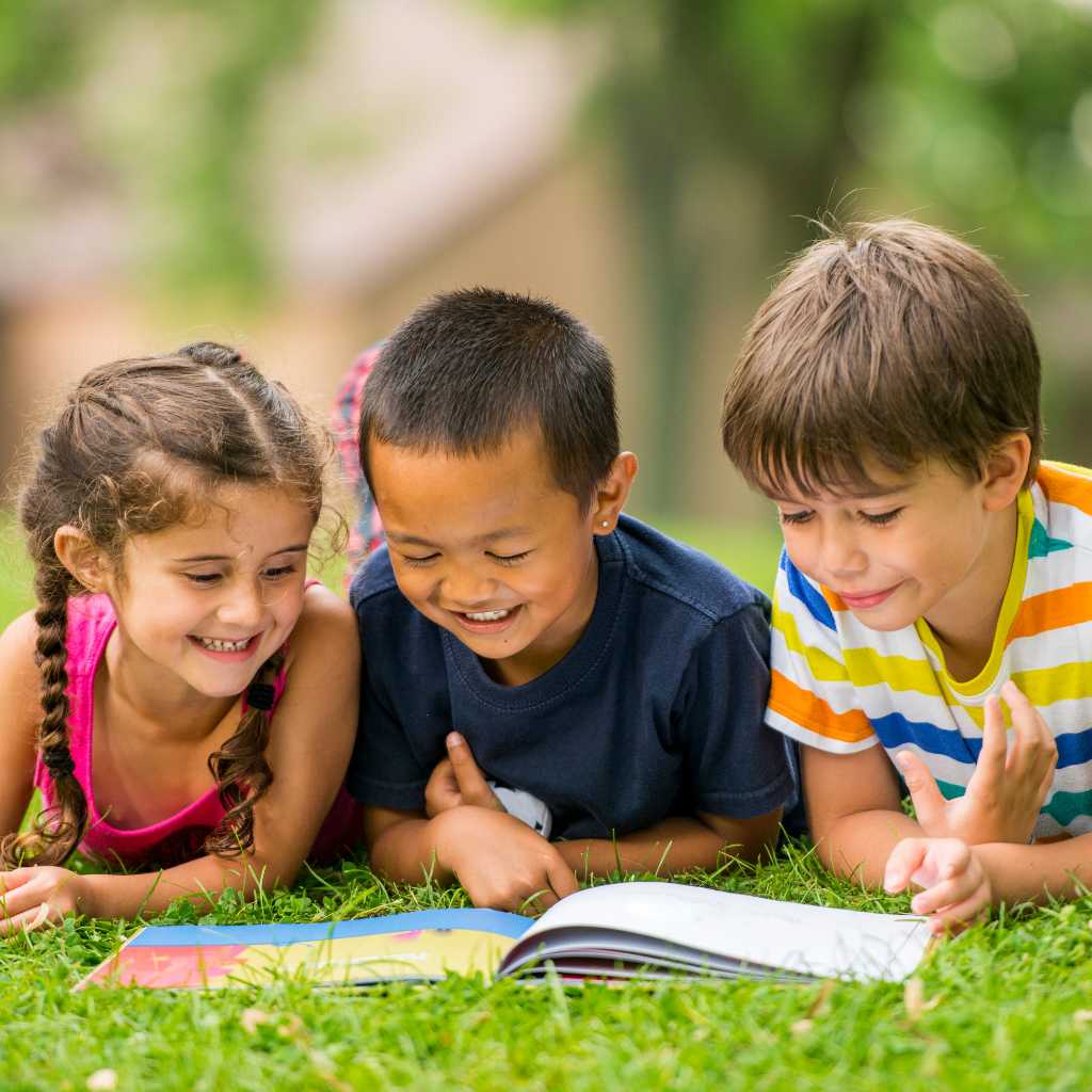Children reading a book together, discovering stories with autistic characters.
