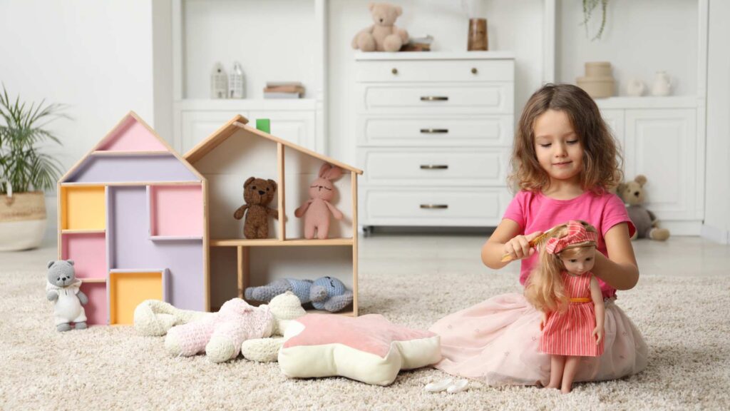 Child sitting on the floor playing with an autistic Barbie doll