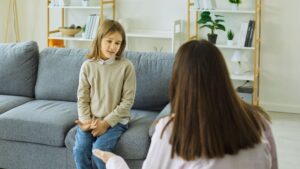 Child speaking with a therapist during an evaluation for “Does my child have autism, or is it just a speech delay?”