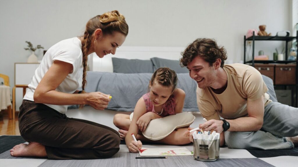 Family supporting a child's unique communication style during a creative drawing activity at home.