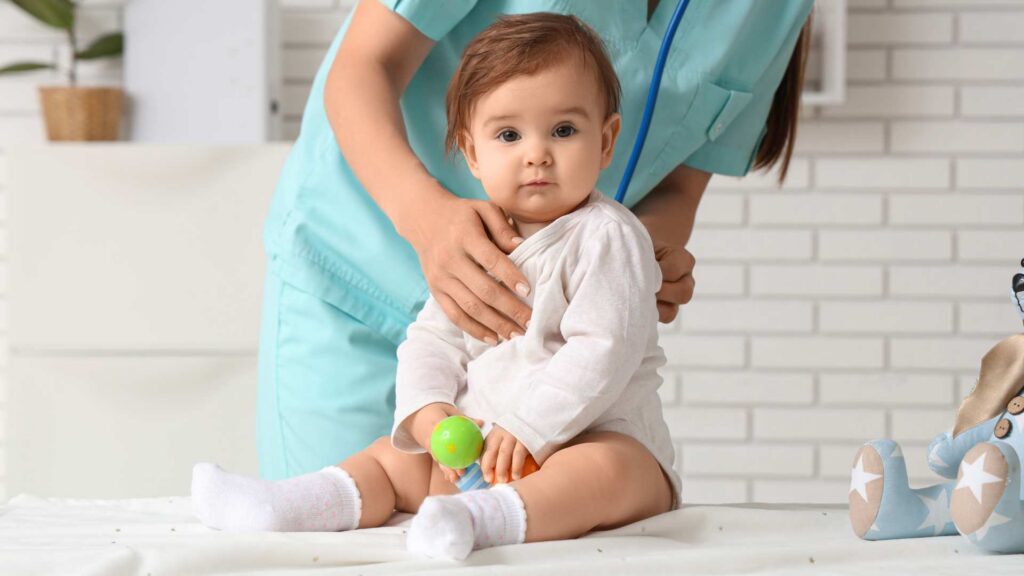 A pediatrician using a stethoscope to examine an 18-month-old during a checkup, demonstrating how to talk to your pediatrician about autism concerns during routine appointments