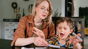 A mother works with her son using flashcards, this image is meant to illustrate how life can look like after an autism diagnosis