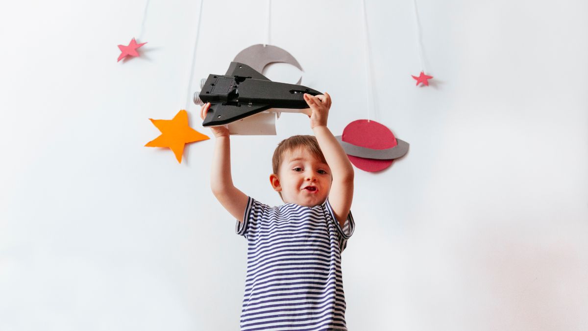 A young boy moves his toy spaceship through crafted planets and stars celebrating May the 4th, Star Wars Day
