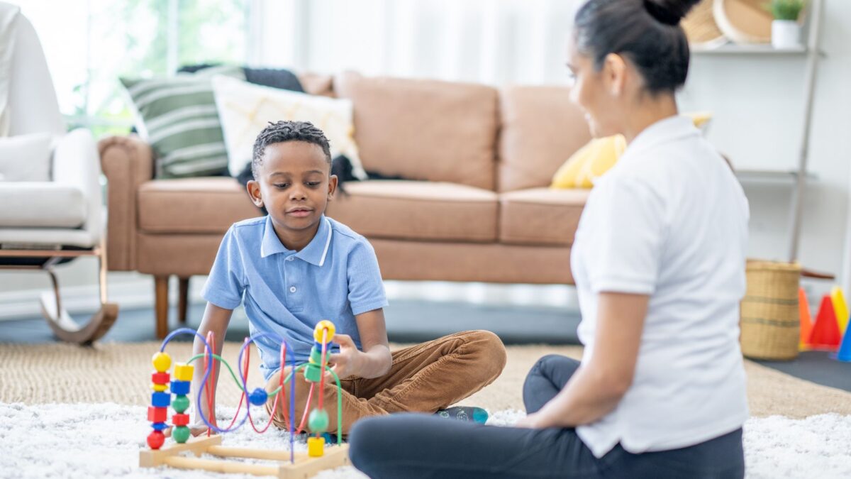 Parent and child sitting on the floor practicing some ABA strategies for parents
