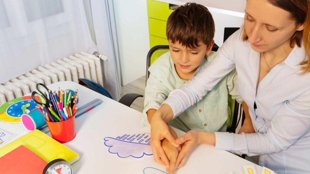 Parent supporting a child during a structured educational activity learned in ABA training for parents