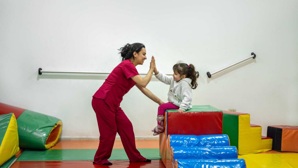 Therapist celebrating a child's success during an ABA therapy session
