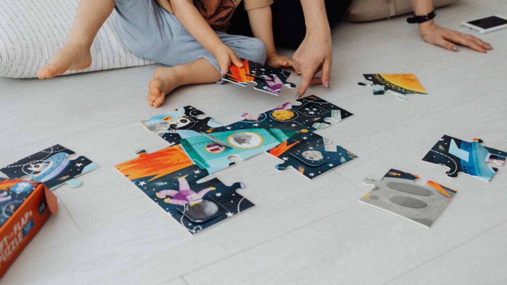 Parent and child completing a puzzle together at home