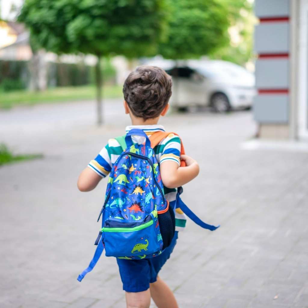 Young child walking independently to school with a backpack