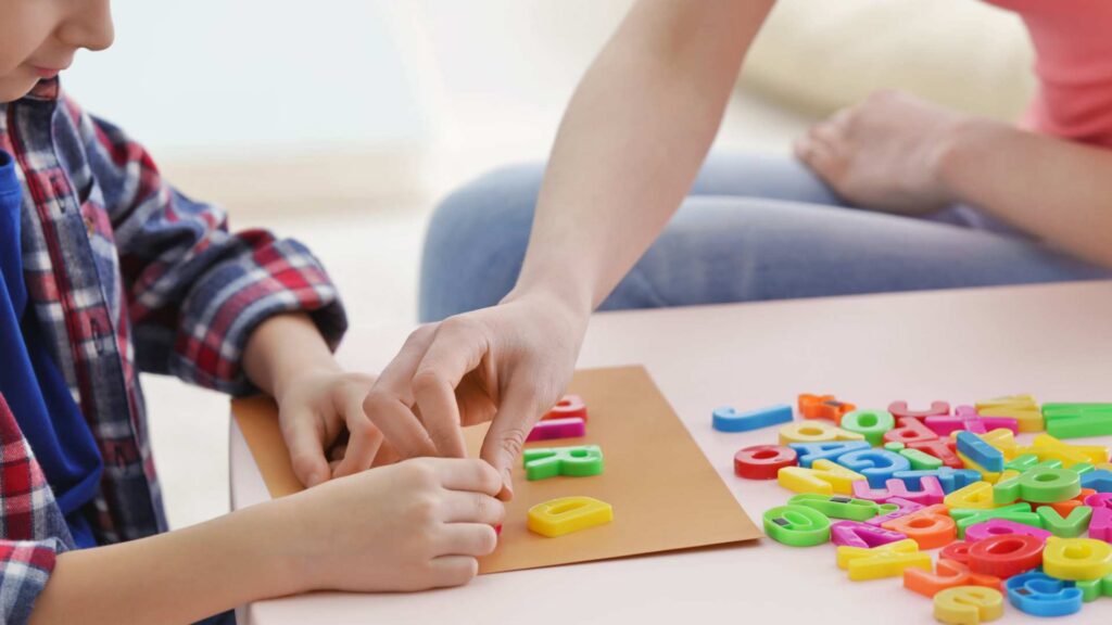 Child working with letters during autism ABA therapy