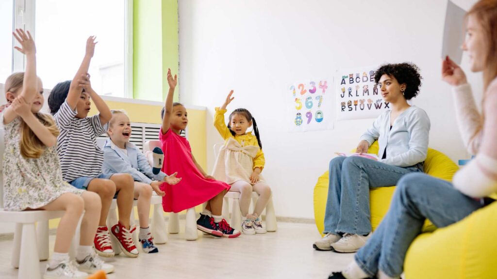 Children with autism in school raising their hands during an inclusive classroom activity