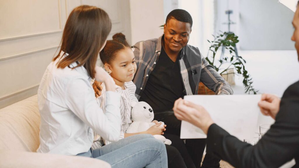 Parents and child meeting with a professionaal explaining autism to family