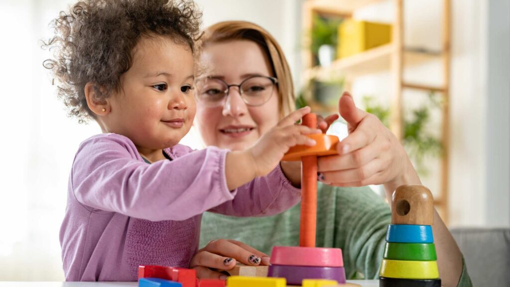 Toddler practicing communication and learning skills during a play-based activity