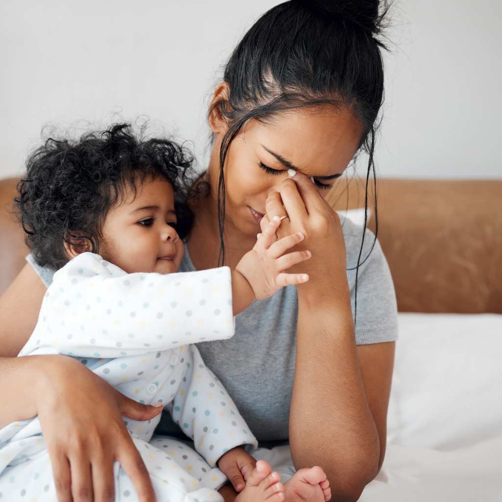 Parent sitting with their toddler, worried, reflecting the emotional weight of how to talk to your pediatrician about autism concerns
