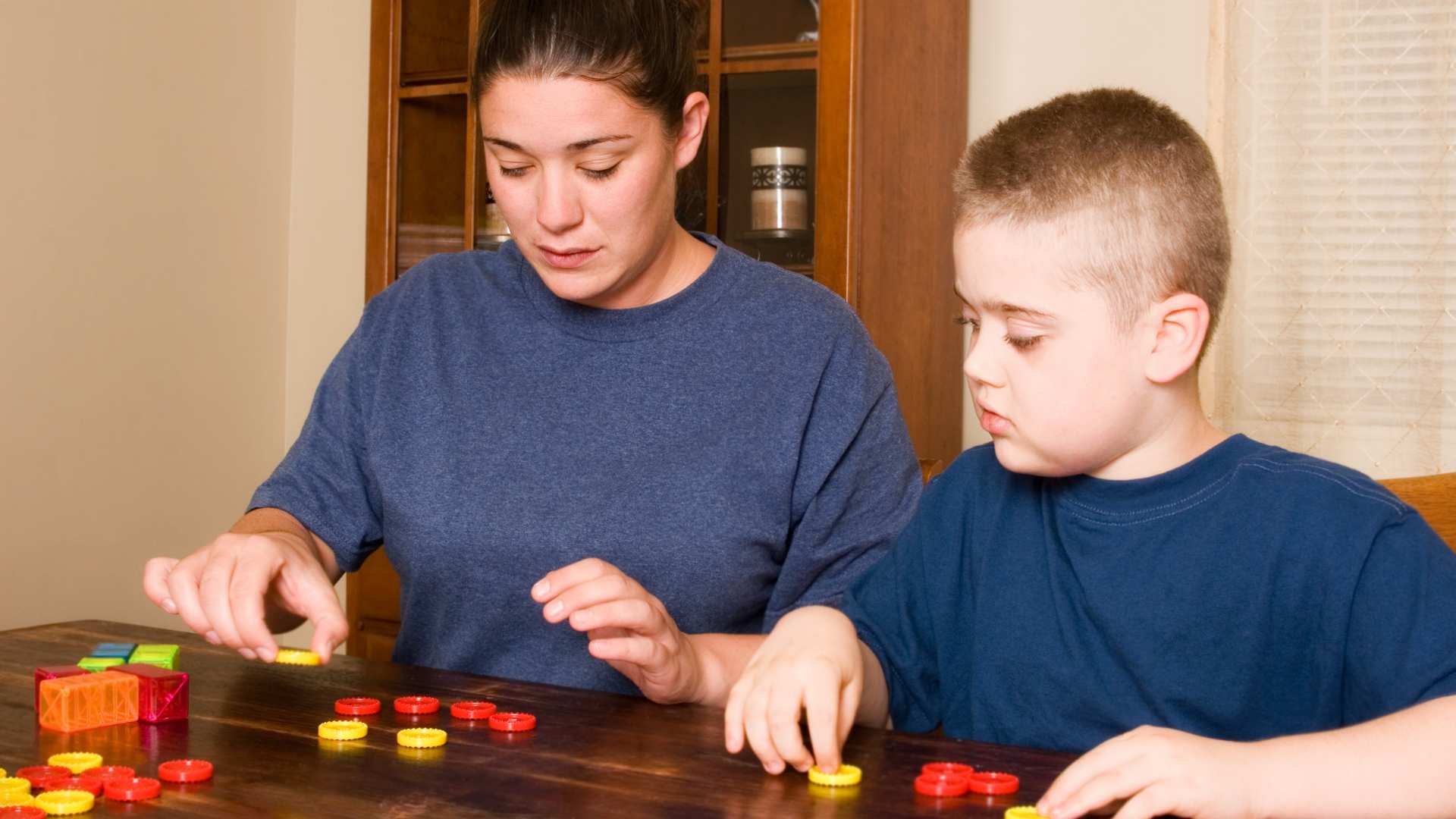 Parent and child working together on a skill-building activity at a table