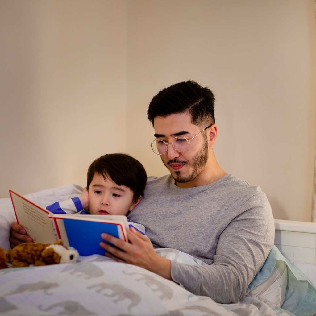 Father parenting a child with autism reading a bedtime story