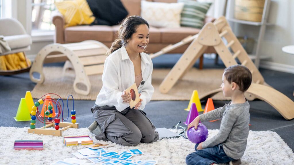 ABA therapist using toys and games during an early intervention session with a young child