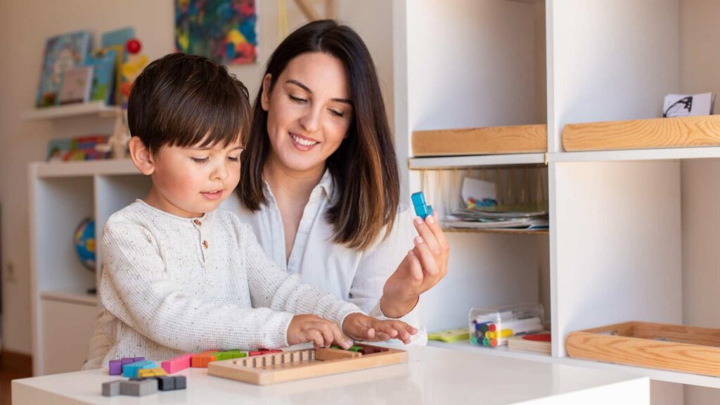 Parent helping a child complete a learning activity that supports progress in ABA therapy