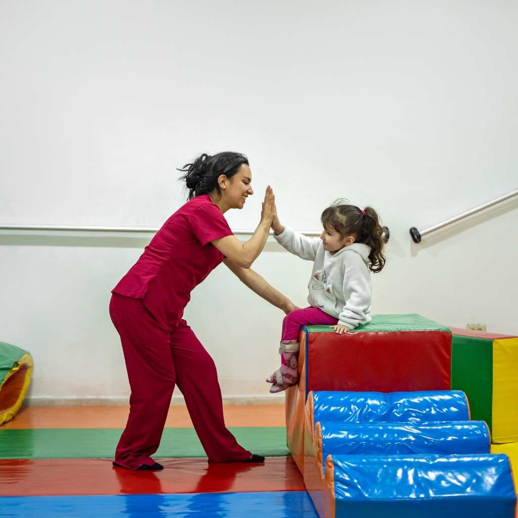 ABA therapist celebrating a child's achievement during a therapy session