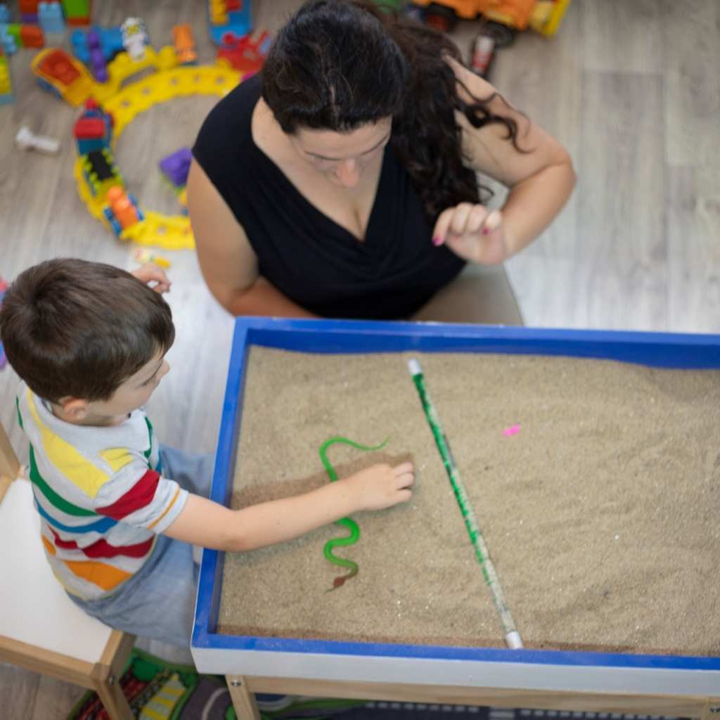 Child and therapist participating in a sensory play activity during ABA therapy